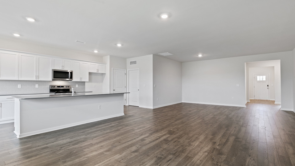 kitchen with quartz counters, kitchen island, pantry, stainless steel appliances