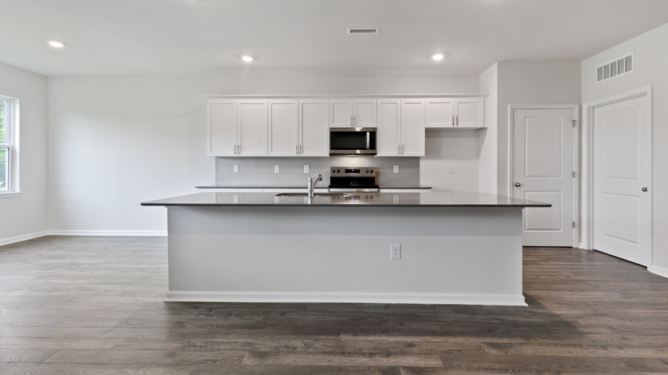 kitchen with quartz counters, kitchen island, pantry, stainless steel appliances