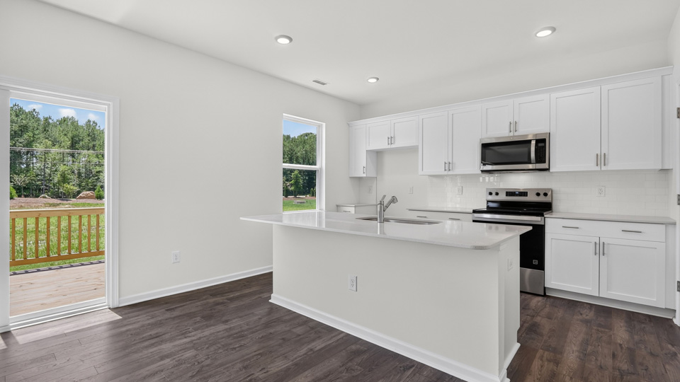 kitchen with quartz counters, kitchen island, pantry, stainless steel appliances