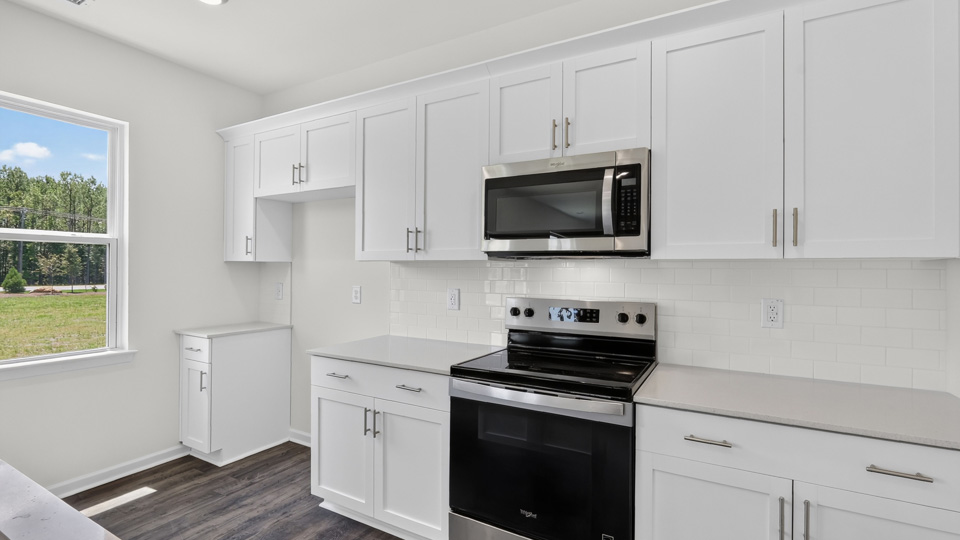 kitchen with quartz counters, kitchen island, pantry, stainless steel appliances