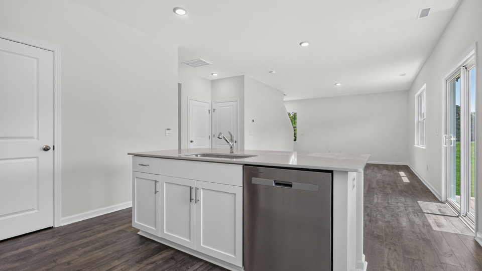 kitchen with quartz counters, kitchen island, pantry, stainless steel appliances