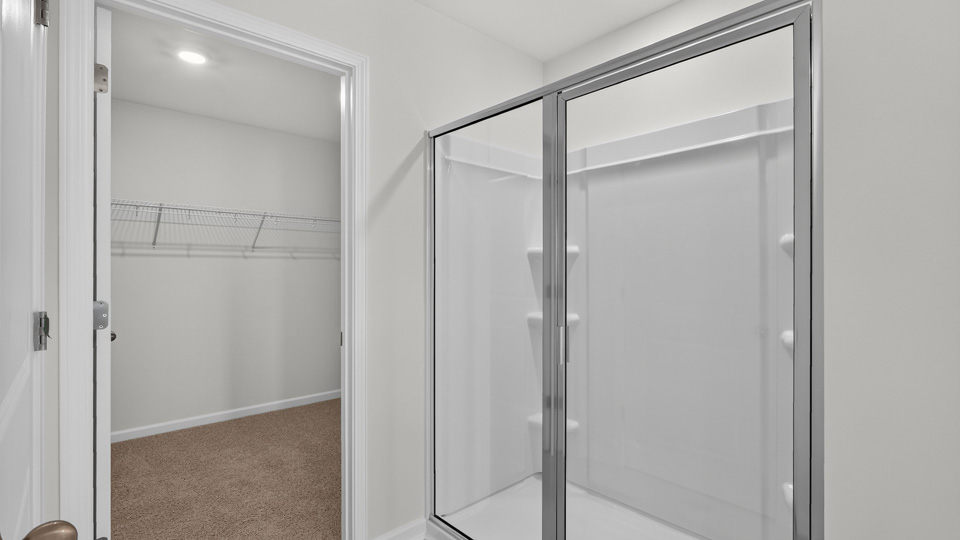 primary bathroom with walk in shower and dual vanity sinks