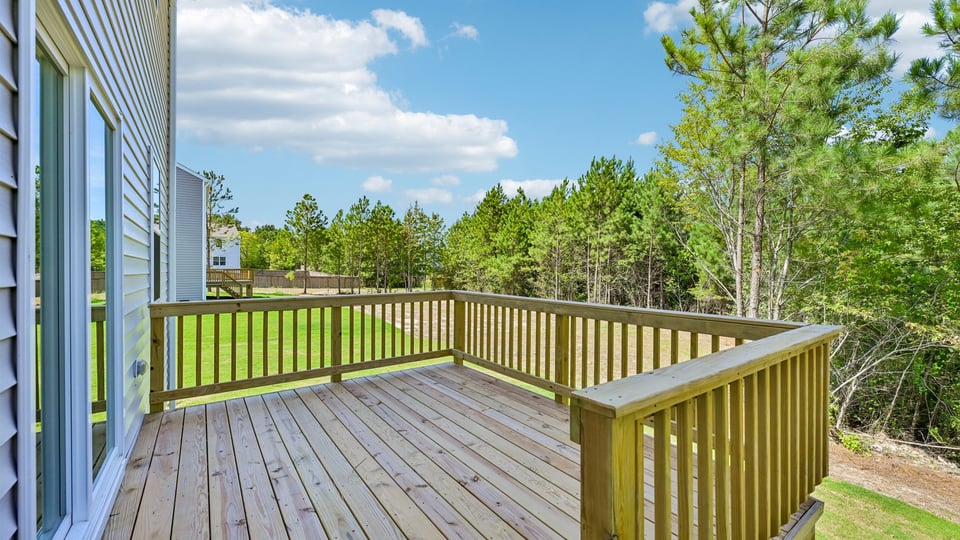 uncovered back deck with treelined back yard