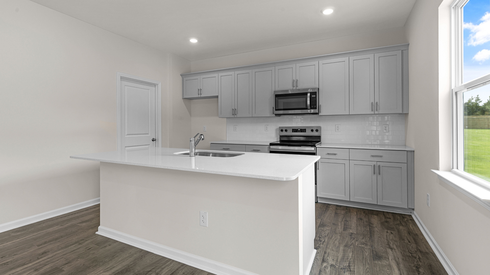 kitchen with quartz counters, kitchen island, pantry, stainless steel appliances