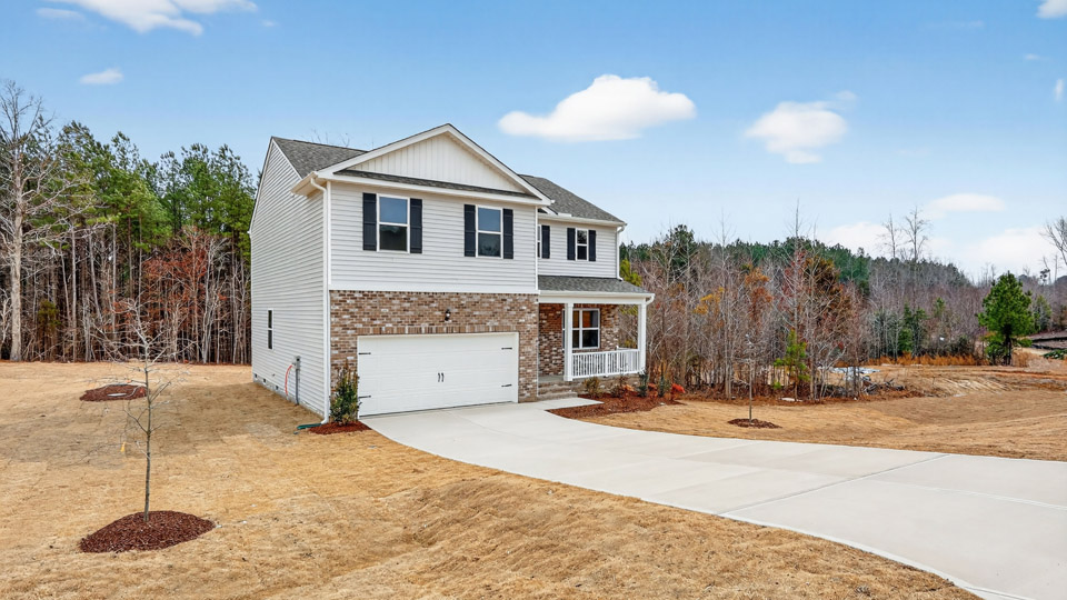 Two story home with white colored siding with a two car garage