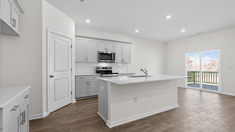 kitchen with quartz counters, kitchen island, pantry, stainless steel appliances