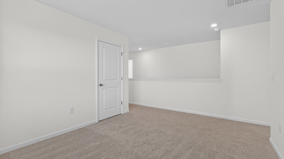 upstairs loft area with large windows and carpeting
