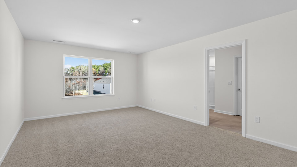 Primary bedroom with carpet and 2 windows