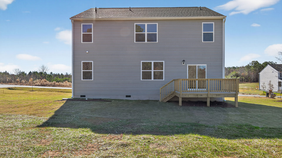 Two story home with gray siding and back deck