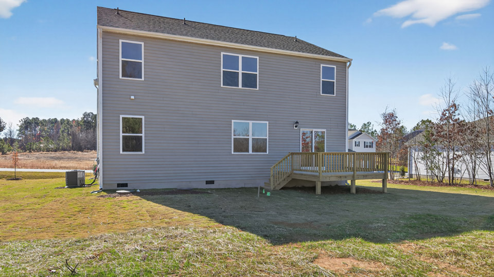 Two story home with gray siding and back deck