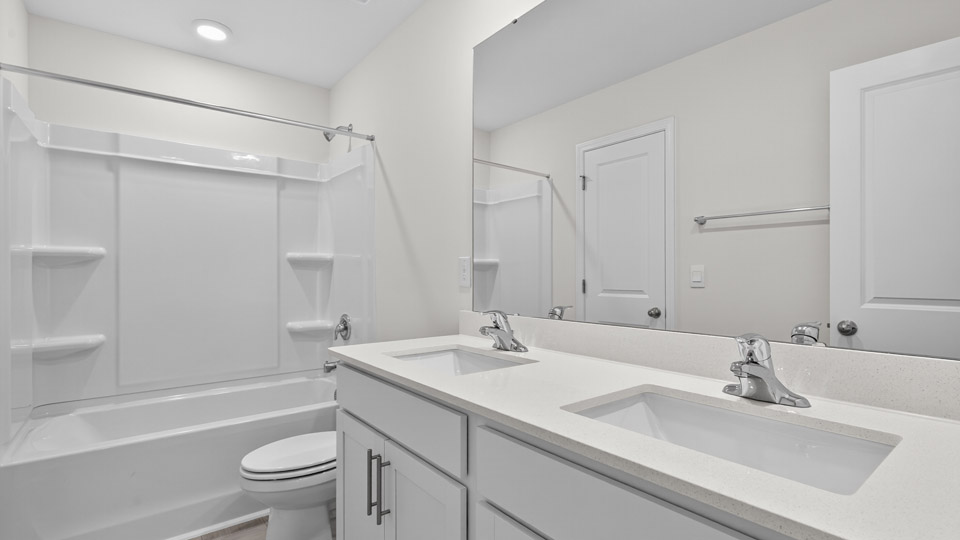 secondary bathroom with shower tub combo and dual vanity sink