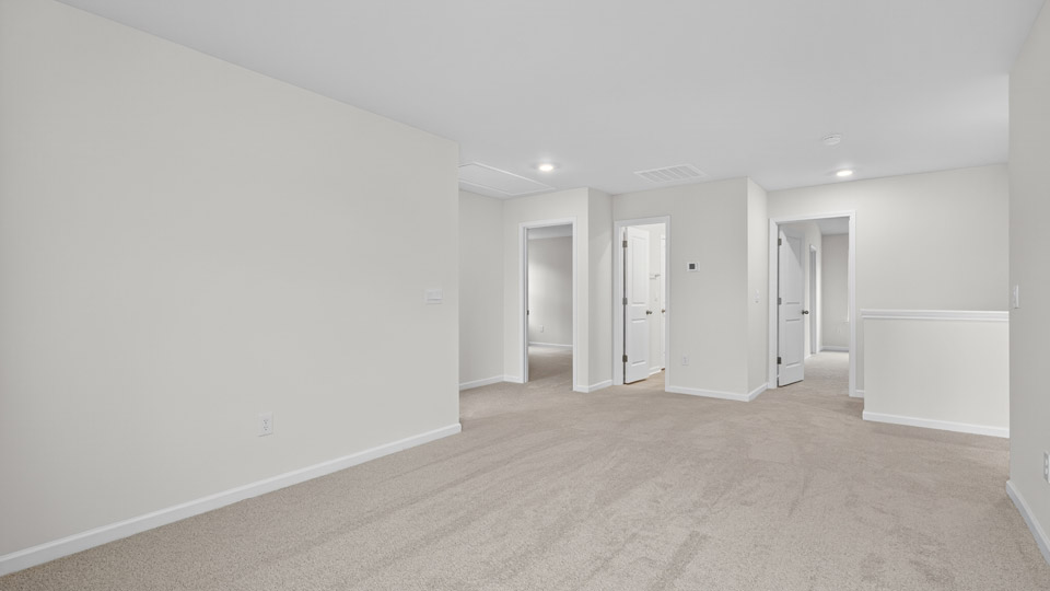 upstairs loft area with large windows and carpeting