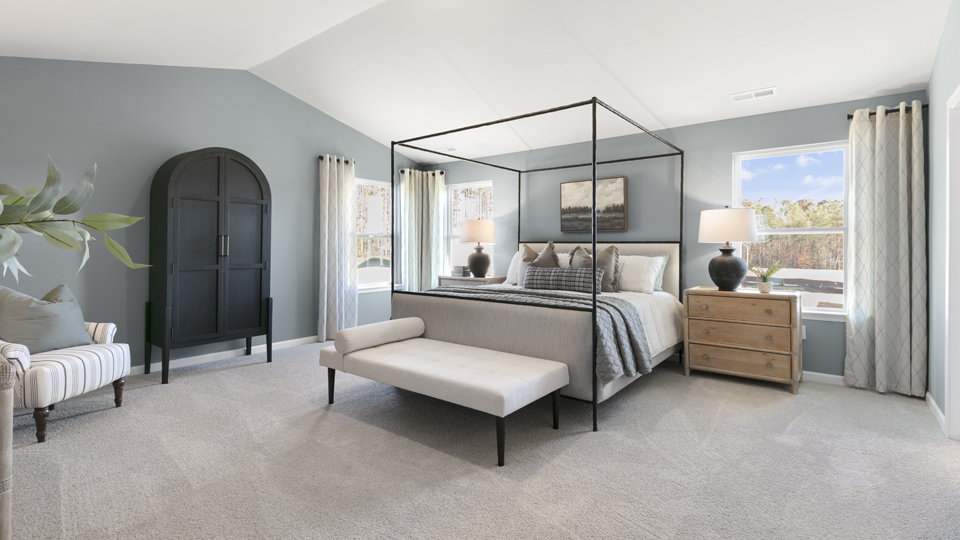 primary bedroom with two windows and carpeting, attached bath