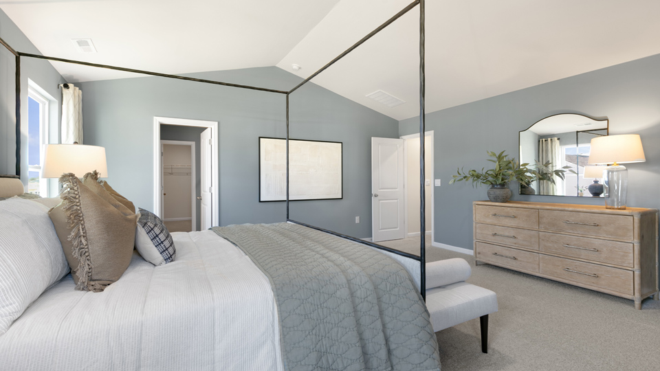 primary bedroom with two windows and carpeting, attached bath