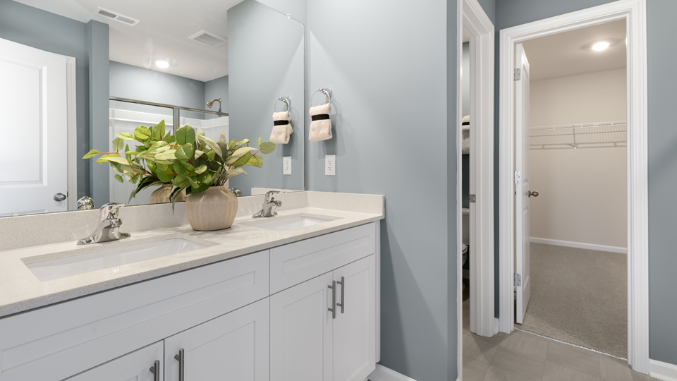 primary bathroom with walk in shower and dual vanity sinks