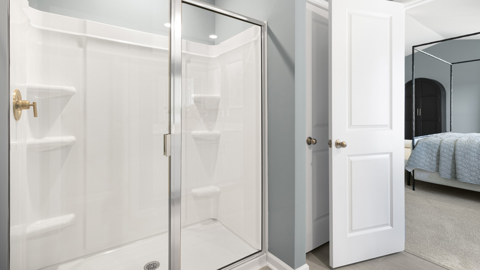 primary bathroom with walk in shower and dual vanity sinks