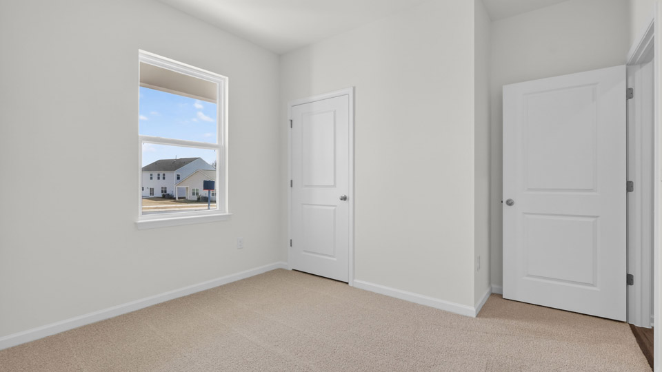 secondary bedroom with window and closet, carpeting