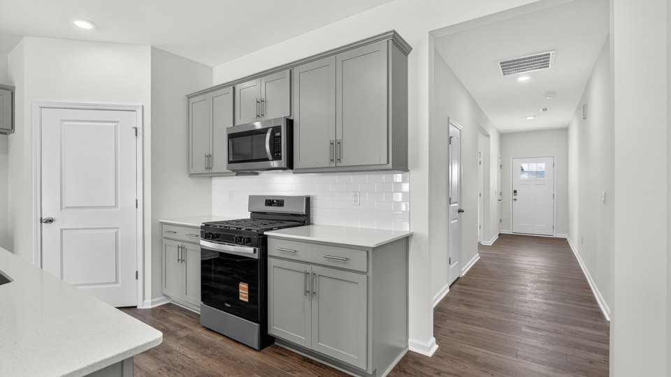 kitchen with quartz counters, kitchen island, pantry, stainless steel appliances