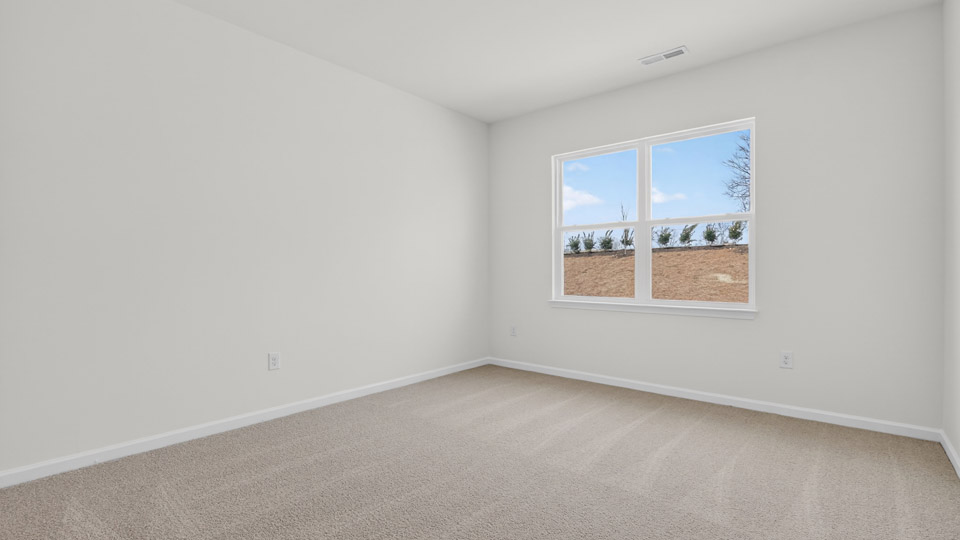 primary bedroom with two windows and carpeting, attached bath