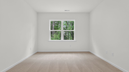 primary bedroom with two windows and carpeting, attached bath