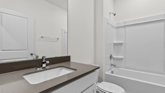 secondary bathroom with shower tub combo and single vanity sink