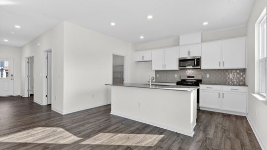kitchen with gray tile backsplash island and quartz countertops