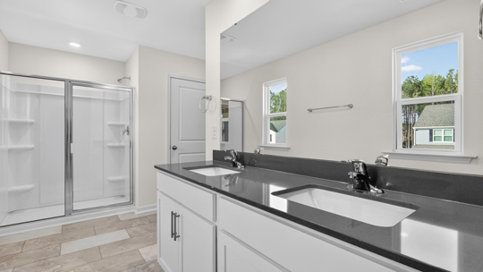 bathroom with dual vanity and walkin glass door shower