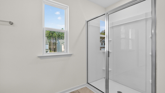 bathroom with window and walk in glass door shower