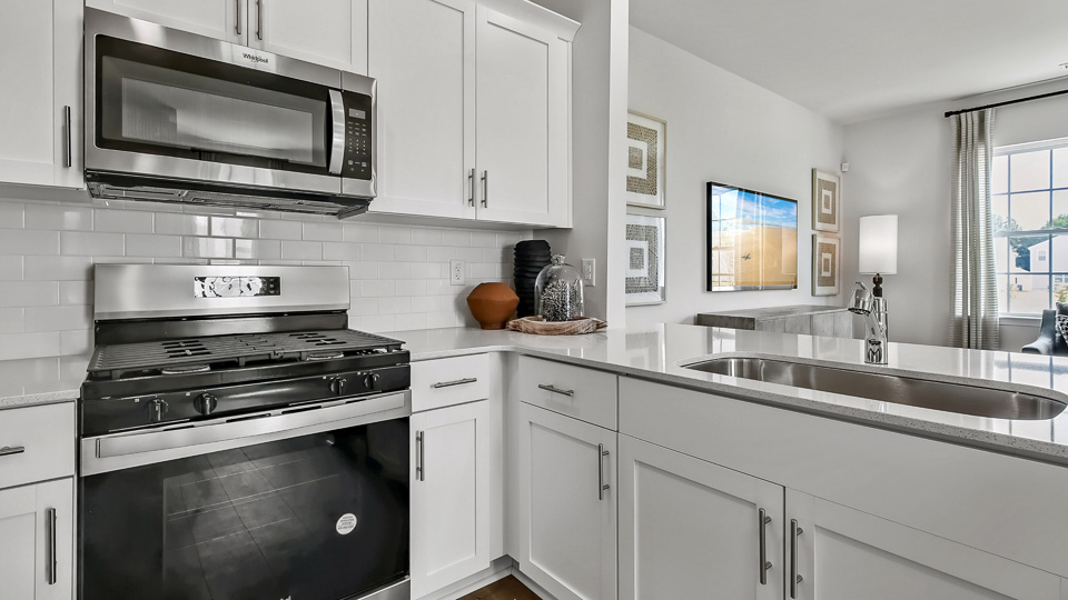 kitchen with quartz counters, kitchen peninsula, pantry, stainless steel appliances