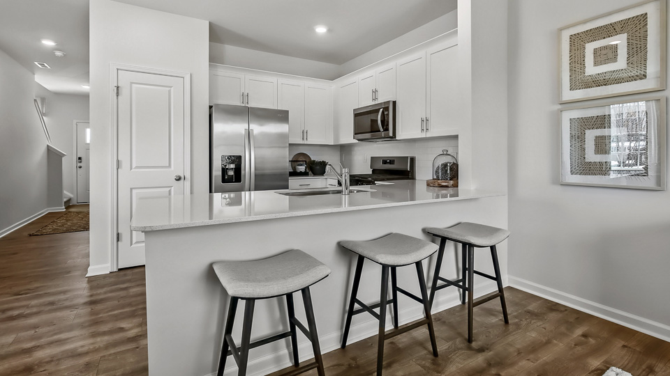 kitchen with quartz counters, kitchen peninsula, pantry, stainless steel appliances