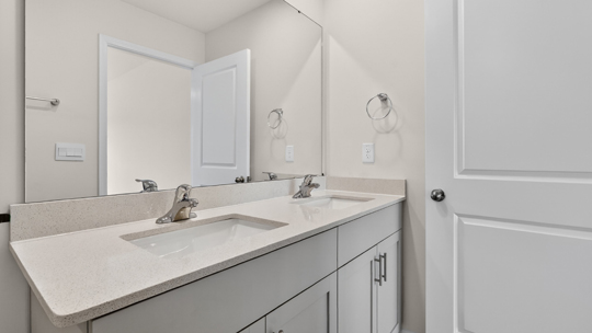 bathroom with quartz countertops and white cabinets