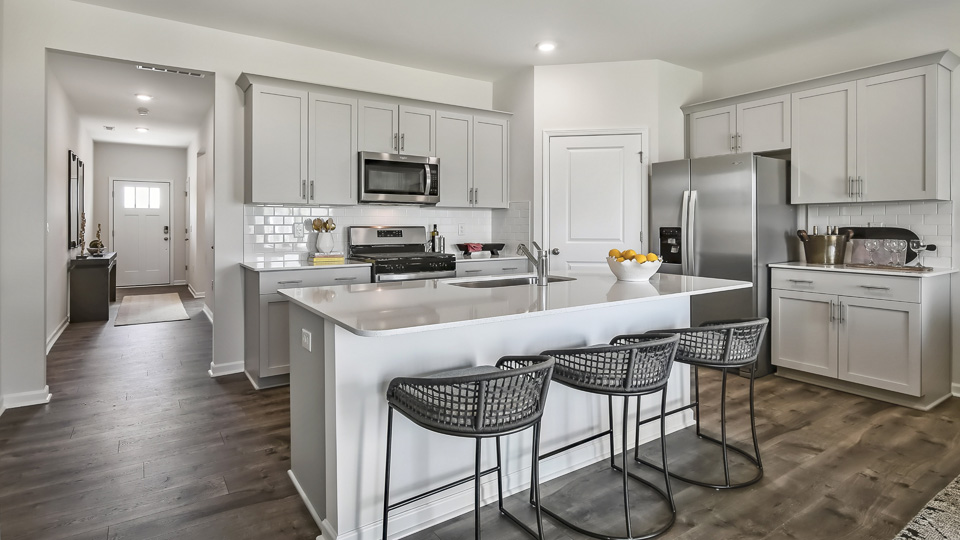 kitchen with quartz counters, kitchen island, pantry, stainless steel appliances