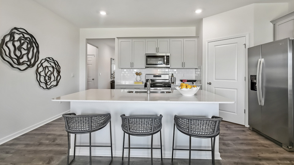 kitchen with quartz counters, kitchen island, pantry, stainless steel appliances