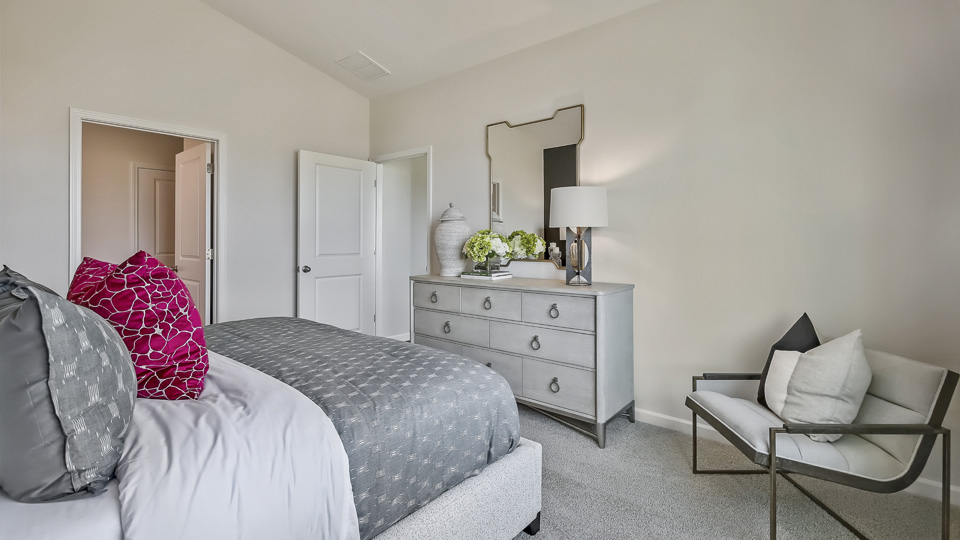 primary bedroom with two windows and carpeting, attached bath