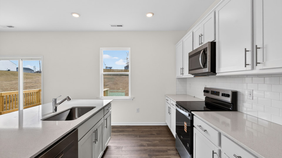 kitchen with quartz counters, kitchen island, pantry, stainless steel appliances