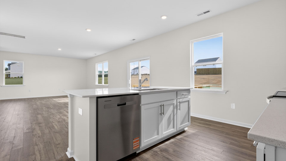 kitchen with quartz counters, kitchen island, pantry, stainless steel appliances