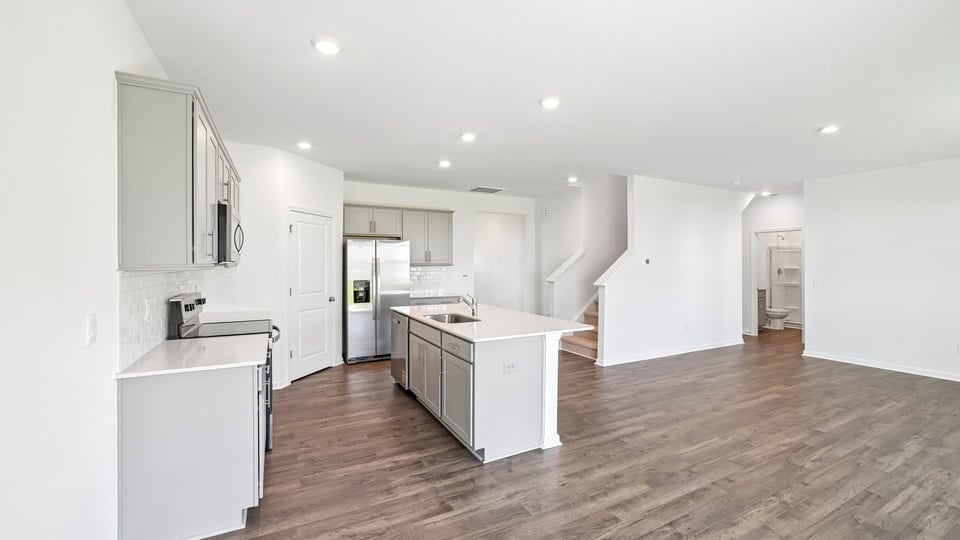 open concept living areas overlooked by kitchen