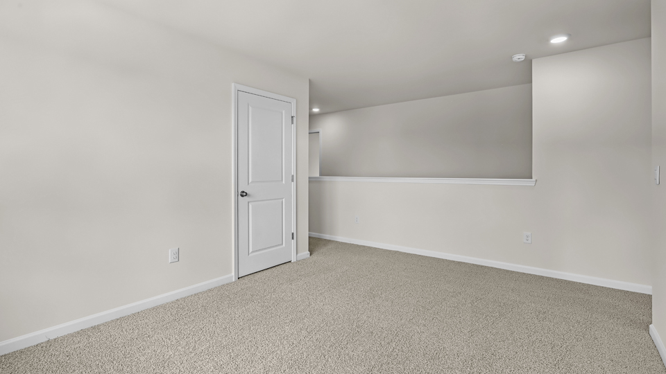 upstairs loft area with large windows and carpeting
