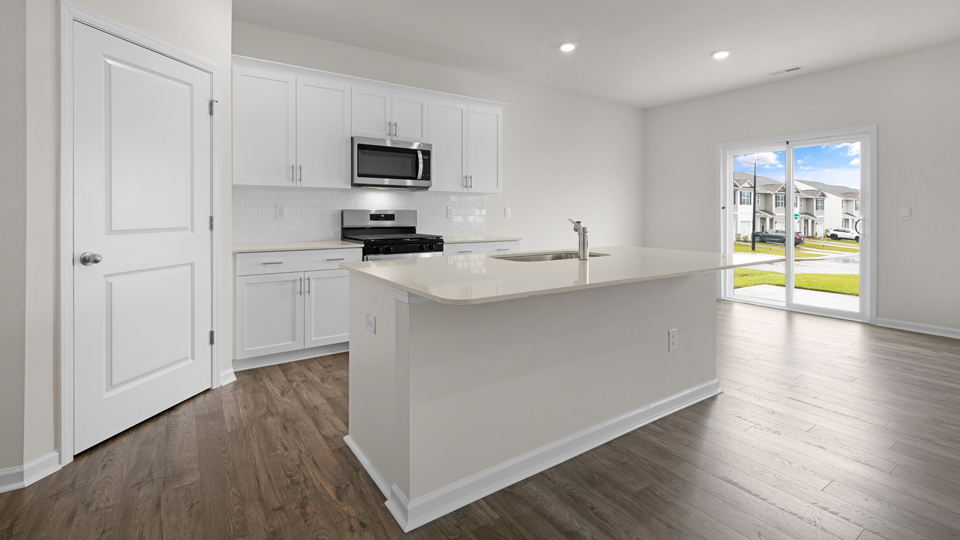 kitchen with quartz counters, kitchen island, pantry, stainless steel appliances