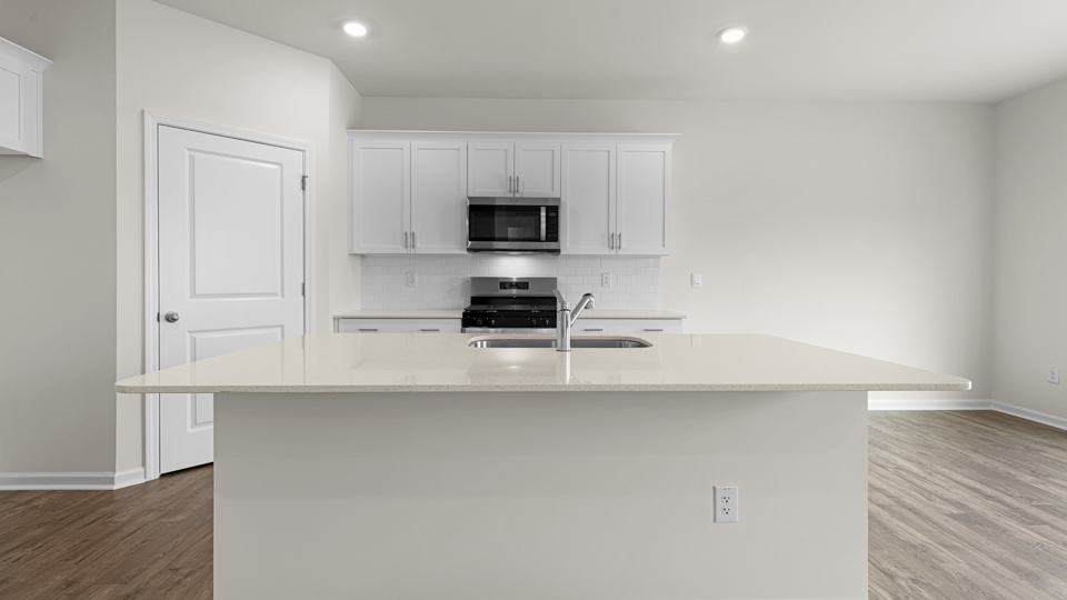 kitchen with quartz counters, kitchen island, pantry, stainless steel appliances