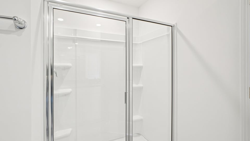 primary bathroom with walk in shower and dual vanity sinks