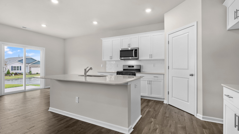 kitchen with quartz counters, kitchen island, pantry, stainless steel appliances