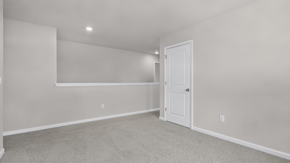upstairs loft area with large windows and carpeting