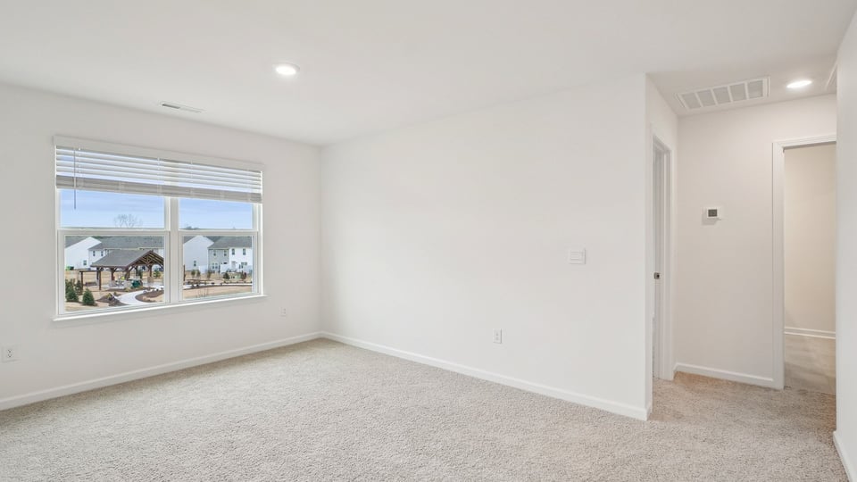 upstairs loft area with large windows and carpeting