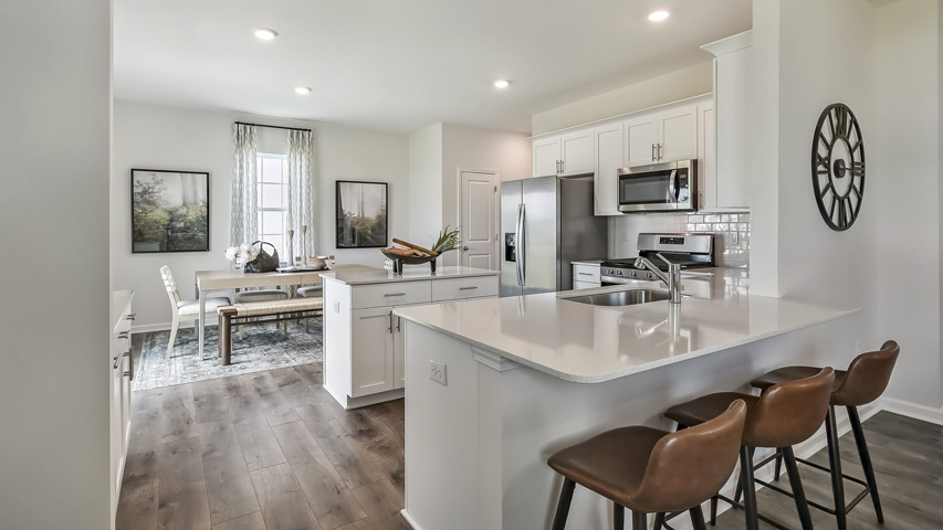 kitchen with quartz counters, kitchen peninsula, pantry, stainless steel appliances