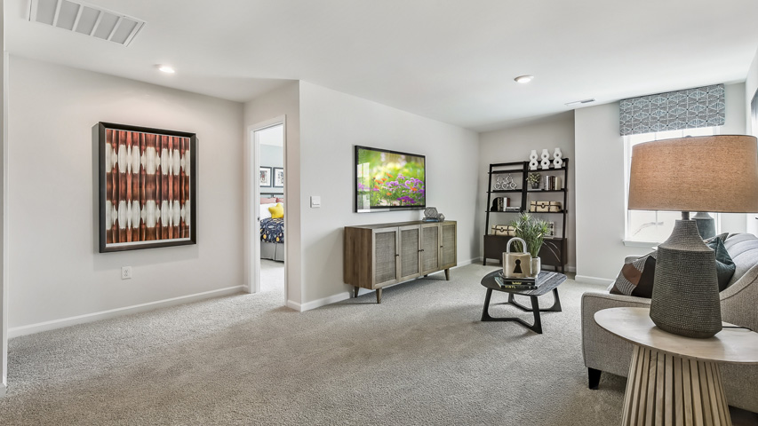 upstairs loft area with large windows and carpeting