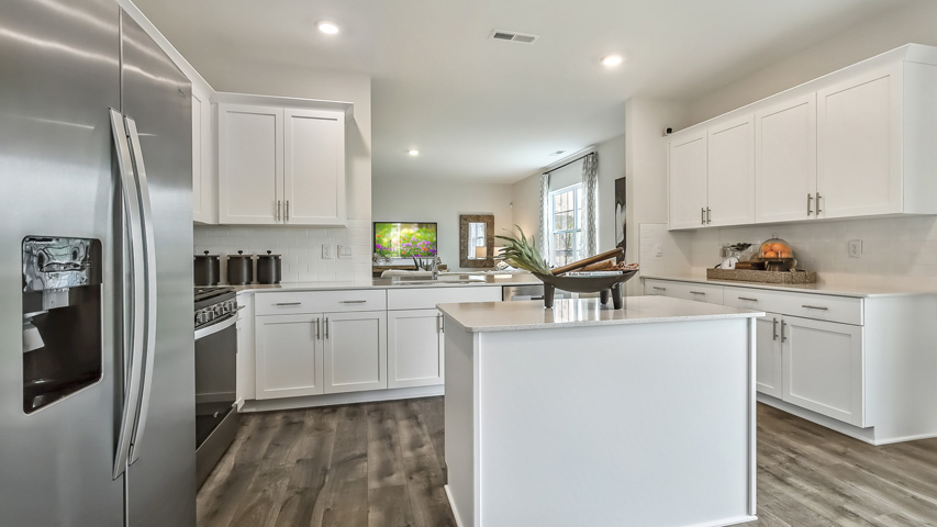 kitchen with quartz counters, kitchen island, pantry, stainless steel appliances