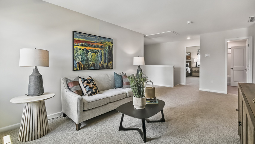 upstairs loft area with large windows and carpeting