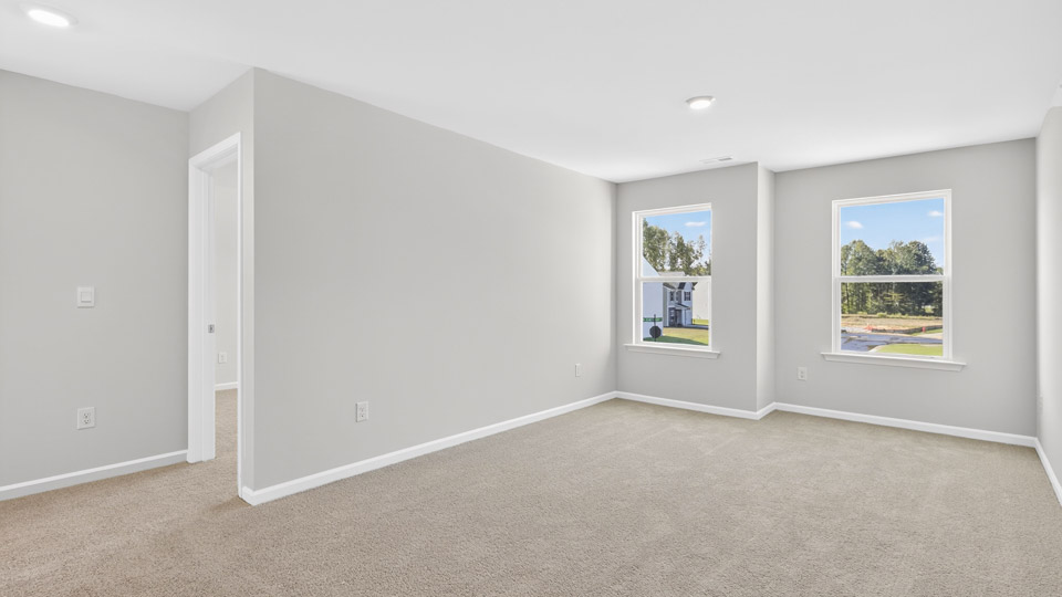 upstairs loft area with large windows and carpeting