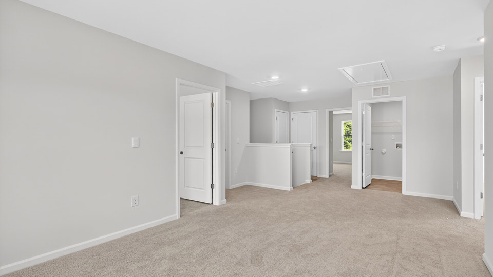 upstairs loft area with large windows and carpeting